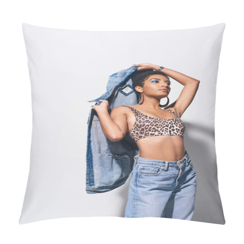 Personality  Trendy Young African American Model In Top With Leopard Print And Jeans Holding Denim Jacket And Looking Away While Standing On Grey Background, Denim Fashion Concept Pillow Covers