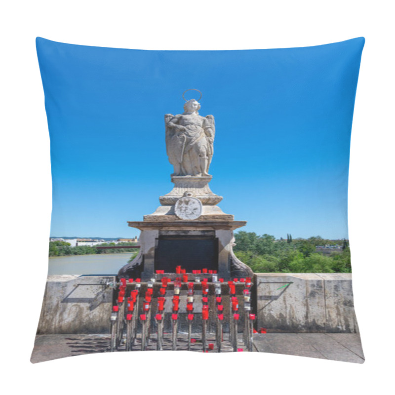 Personality  A Statue Of St. Raphael On The Roman Bridge In Cordoba, With Red Candles Placed At The Base Against A Clear Sky. Pillow Covers