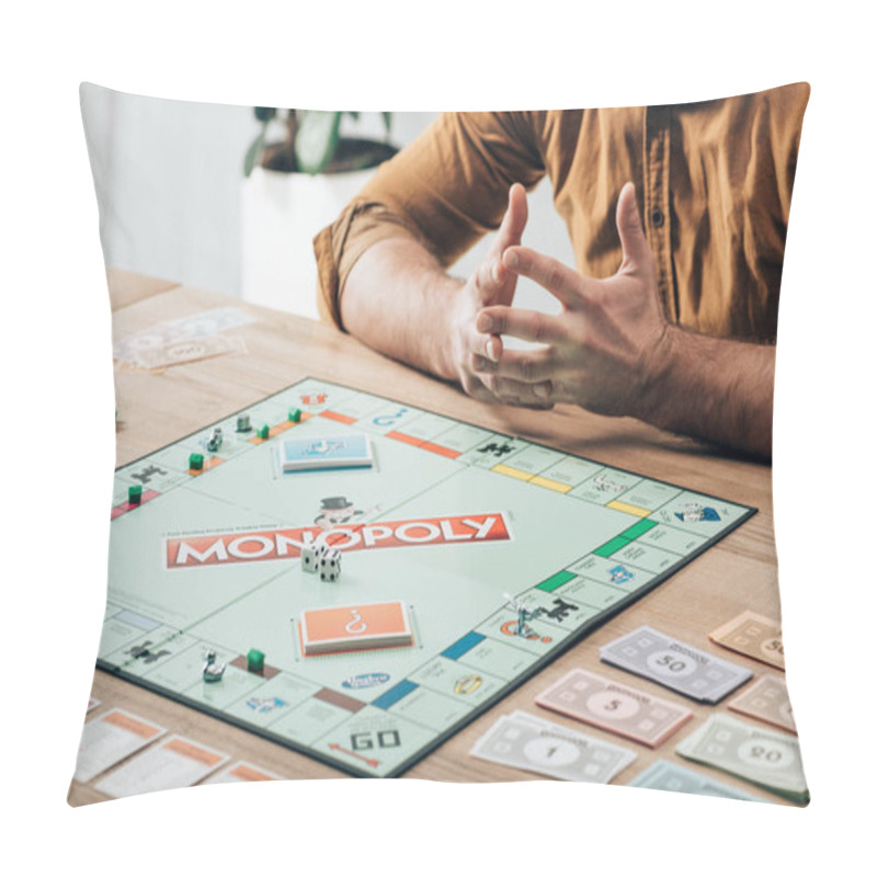 Personality  KYIV, UKRAINE - NOVEMBER 15, 2019: Cropped View Of Man Sitting At Table With Monopoly Game Pillow Covers