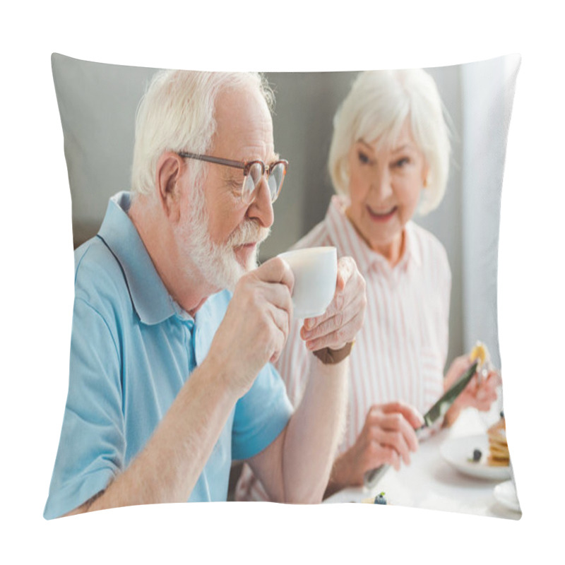 Personality  Selective Focus Of Senior Man Drinking Coffee By Smiling Wife With Pancakes During Breakfast Pillow Covers