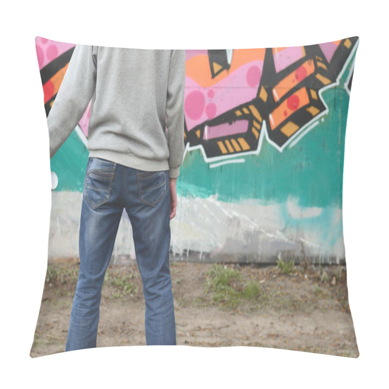 Personality  A Young Graffiti Artist In A Gray Hoodie Looks At The Wall With His Graffiti In Pink And Green Colors On A Wall In Rainy Weather. Street Art Concept Pillow Covers