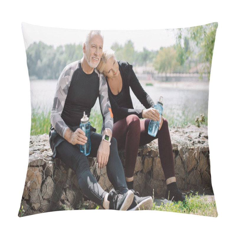 Personality  Smiling Mature Sportsman And Sportswoman Sitting On Parapet In Park And Holding Sports Bottles Pillow Covers