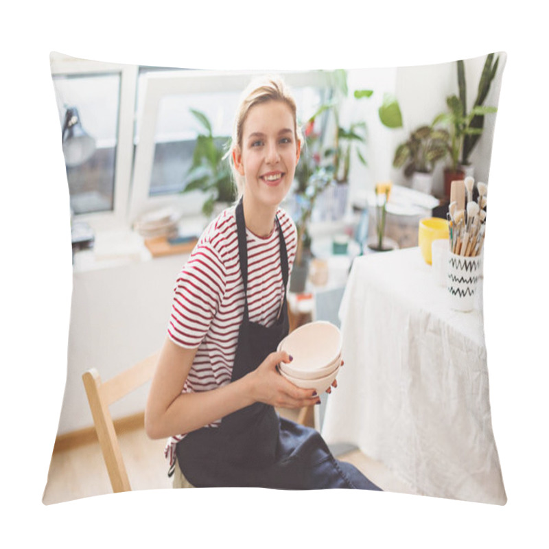 Personality  Beautiful Smiling Girl In Black Apron And Striped T-shirt Holding Handmade Clay Bowls In Hands Joyfully Looking In Camera At Modern Pottery Studio Pillow Covers