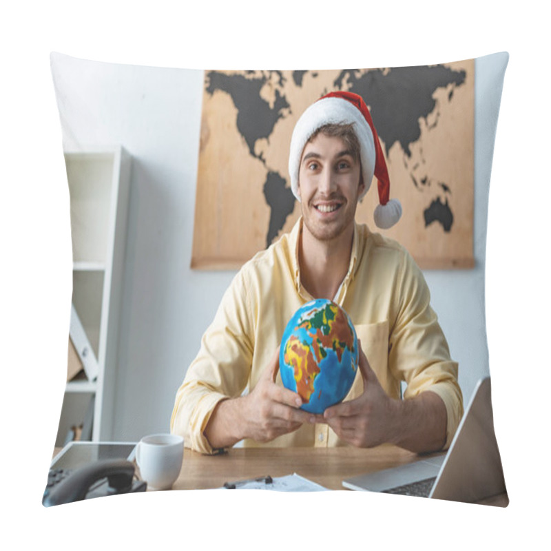 Personality  Handsome Travel Agent In Santa Hat Holding Globe While Smiling At Camera Pillow Covers