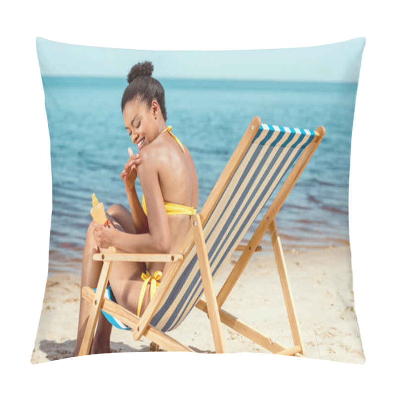 Personality  Smiling African American Woman Applying Sunscreen Lotion On Skin While Sitting On Deck Chair On Sandy Beach  Pillow Covers