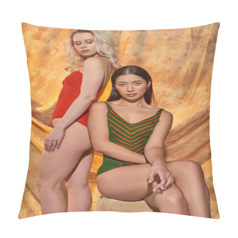 Personality  Young Multicultural Women In Stylish Swimsuits Looking At Camera On Beige Background With Drapery Pillow Covers