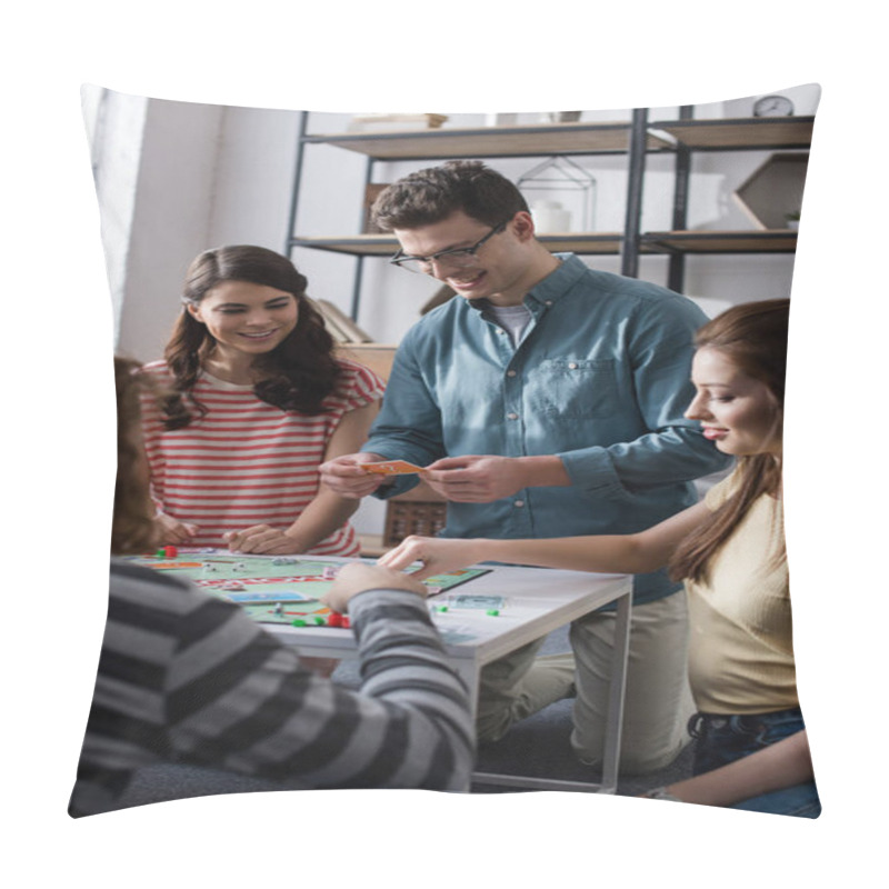 Personality  KYIV, UKRAINE - JANUARY 27, 2020: Cheerful Man Holding Card While Playing Monopoly Game With Smiling Friends Pillow Covers