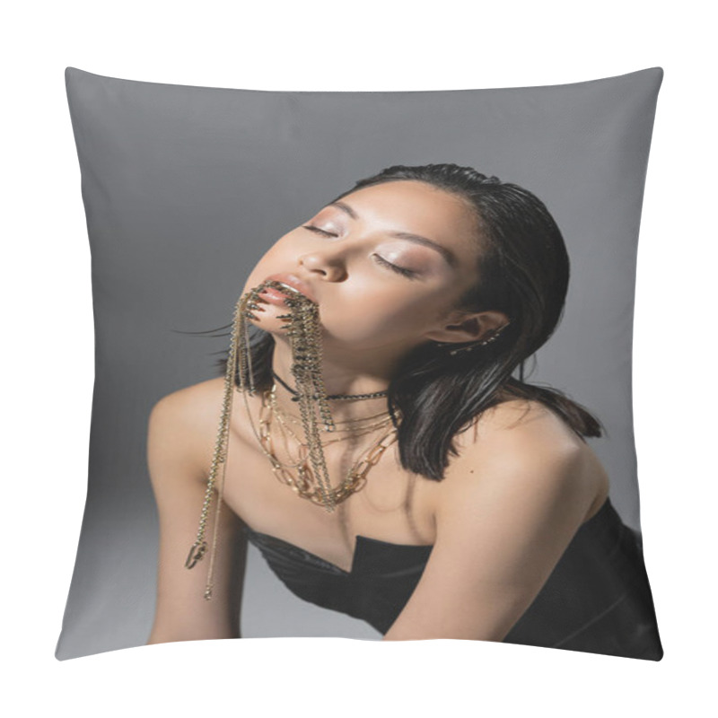 Personality  Portrait Of Fashionable Asian Young Model With Short Hair And Closed Eyes Posing In Black Strapless Dress While Holding Golden Jewelry In Mouth On Grey Background, Wet Hairstyle, Natural Makeup Pillow Covers