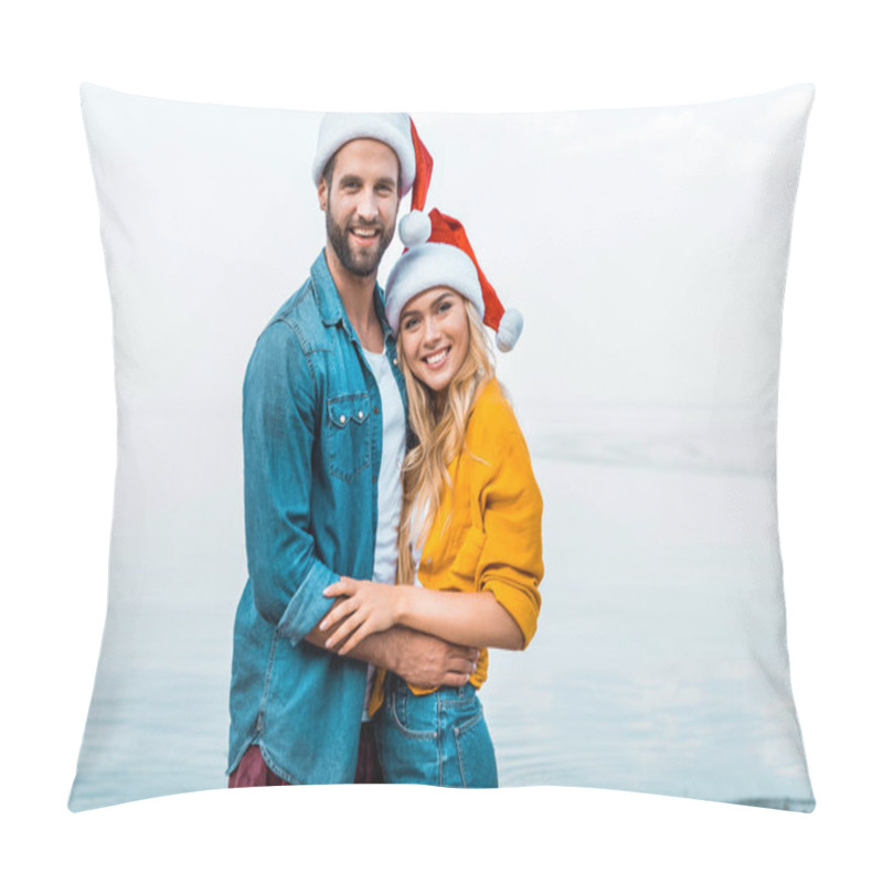 Personality  Smiling Couple In Santa Hats Hugging On Beach And Looking At Camera Pillow Covers