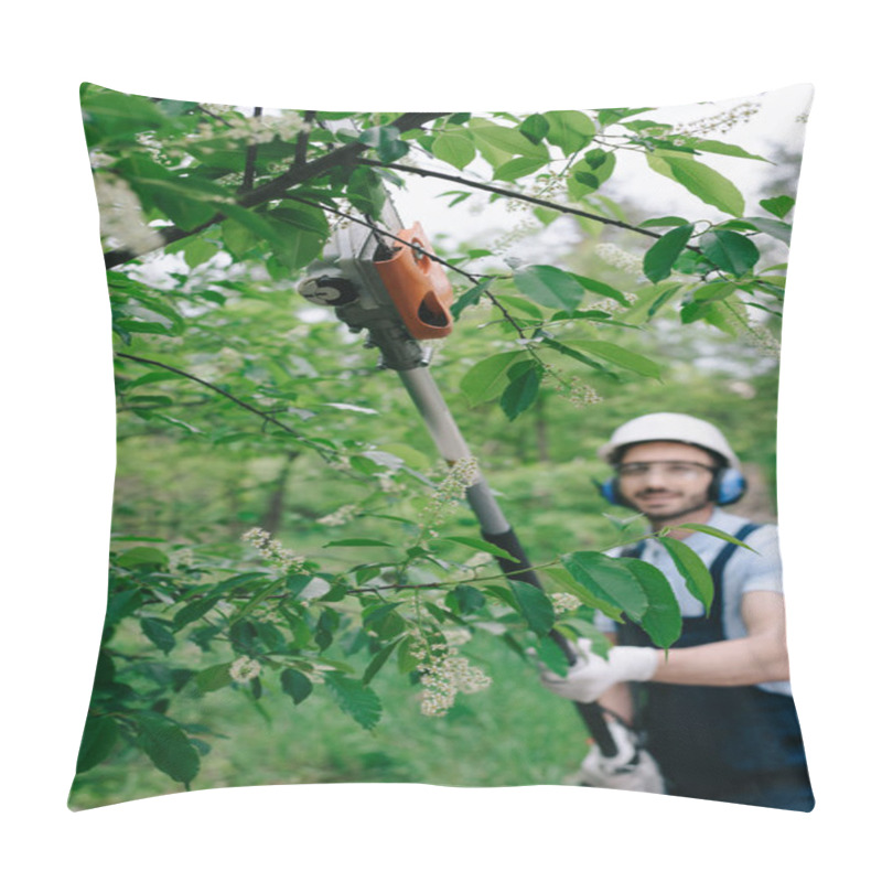 Personality  Selective Focus Of Smiling Gardener In Helmet And Hearing Protectors Trimming Trees With Telescopic Pole Saw And Looking At Camera Pillow Covers