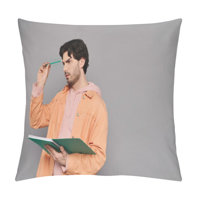 Personality  A Young Man Holds A Notebook And Pen, Deep In Thought Against A Neutral Background. Pillow Covers