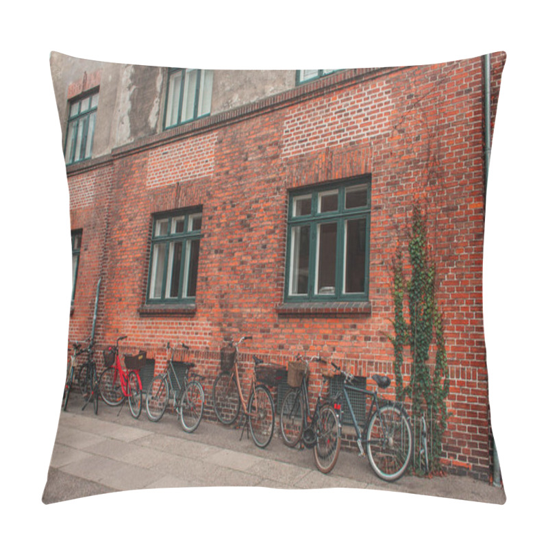 Personality  Row Of Bikes Near Brick Facade Of Building On Urban Street, Copenhagen, Denmark  Pillow Covers