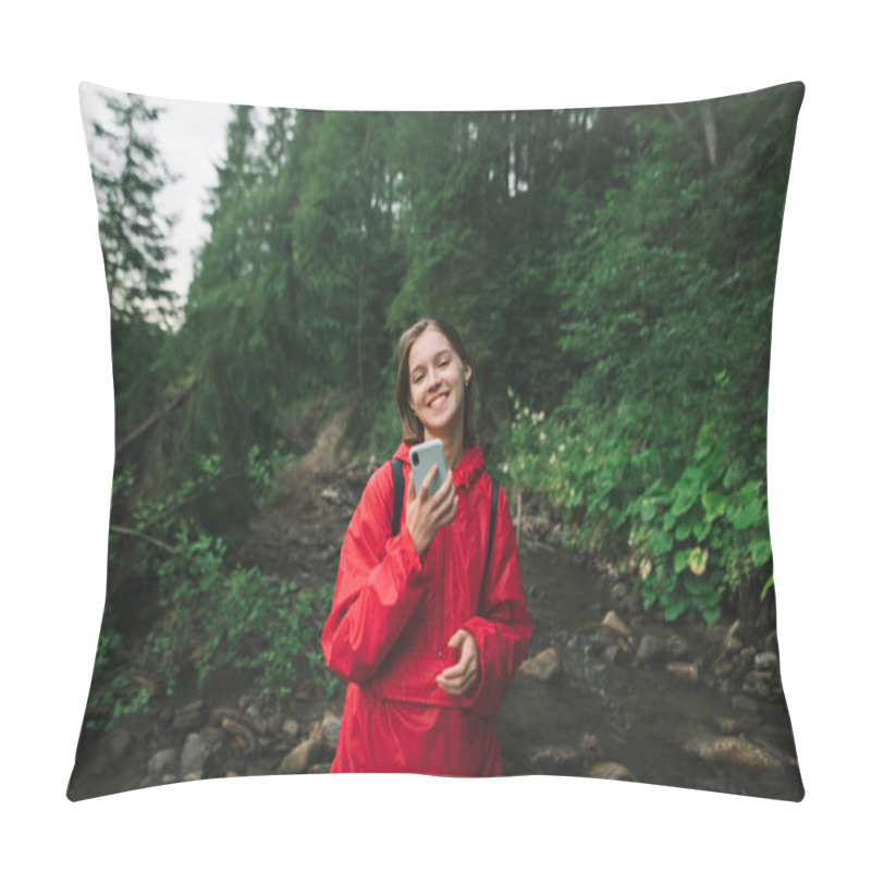 Personality  Portrait Of Smiling Hiker Girl In Forest With Smartphone In Hand, Wearing Red Raincoat, Standing On Background Of Mountain Stream And Wild Plants. Happy Girl On A Hike Uses A Smartphone. Pillow Covers