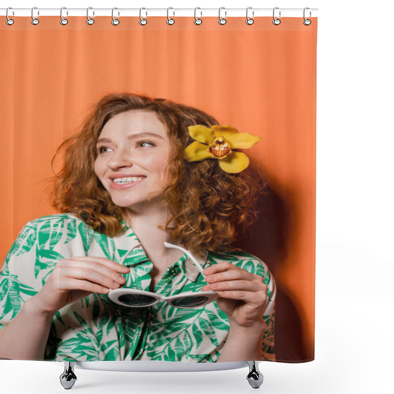 Personality  Smiling Young Redhead Woman With Orchid Flower In Hair Wearing Blouse With Floral Print And Holding Sunglasses While Standing On Orange Background, Summer Casual And Fashion Concept, Youth Culture Shower Curtains