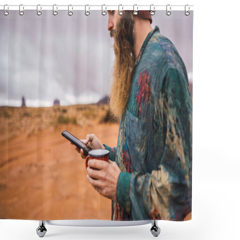 Personality  Side View Of Crop Bearded Man With Mug Of Fresh Hot Drink Browsing Modern Smartphone While Standing In Amazing Monument Valley On Cloudy Day In Utah Shower Curtains