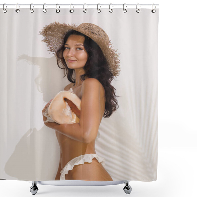 Personality  A Cheerful Woman With Dark Hair, Wearing A Straw Hat And White Bikini Bottoms, Poses Holding A Large Seashell Against A Sunlit Wall With Intricate Shadows. Perfect For Summer And Beach-themed Ads And Shower Curtains