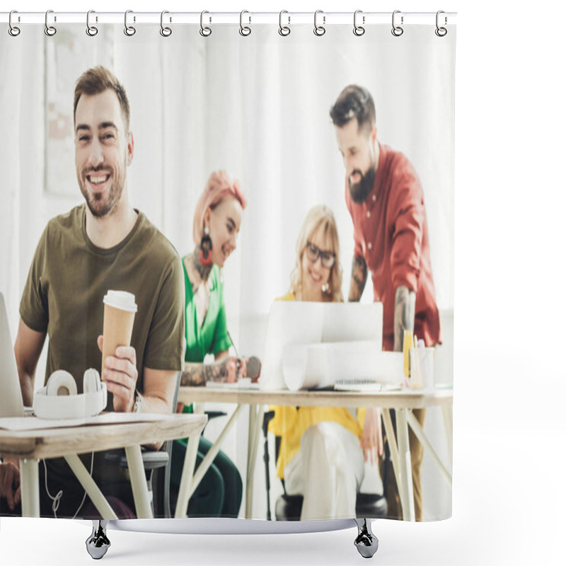 Personality  Selective Focus Of Smiling Man With Coffee To Go And Creative Colleagues Working Behind In Office Shower Curtains