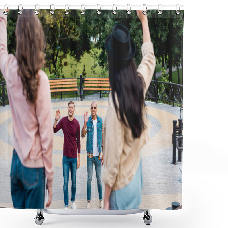 Personality  Selective Focus Of Cheerful Young Multicultural Men Waving Hand And Smiling To Female Friends In Park Shower Curtains