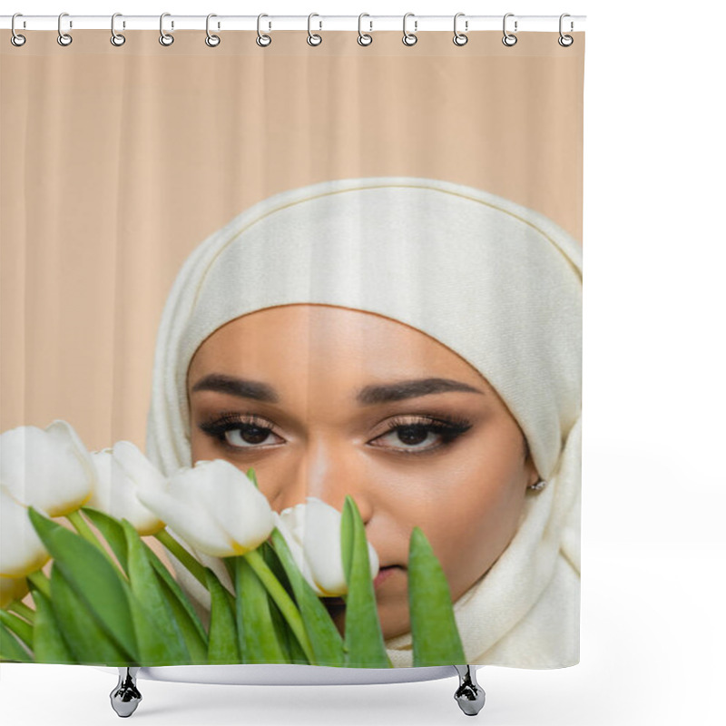 Personality  Portrait Of Muslim Woman In Hijab Looking At Camera Through Tulips Isolated On Beige Shower Curtains