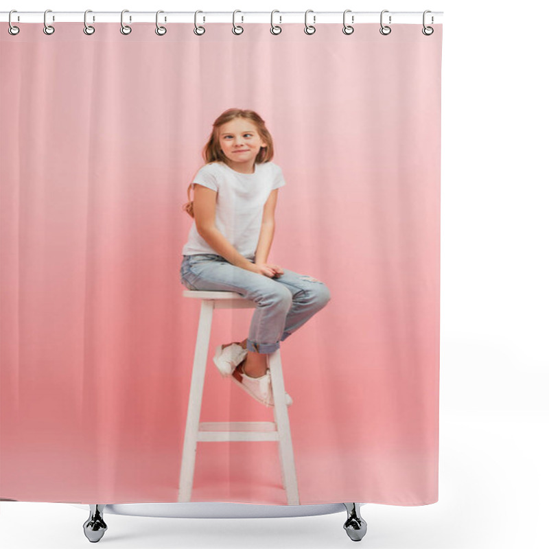 Personality  Kid In White T-shirt And Jeans Grimacing And Squinting While Sitting On High Stool On Pink Shower Curtains