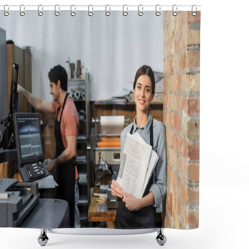 Personality  Joyful Typographer In Apron Holding Newspapers Near Colleague On Blurred Background  Shower Curtains