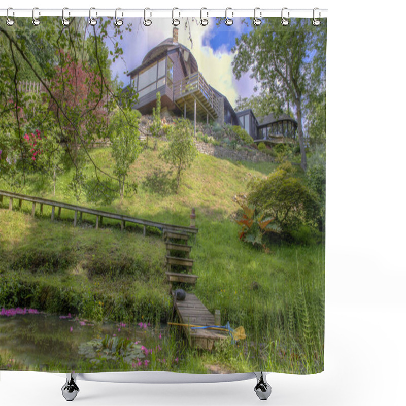 Personality  A Low Down Perspective Of A Green Downhill Meadow On A Bright Sunny Day, There Is A Small Stream Of Water Flowing At The Bottom Of The Meadow And A Wooden Walkway Leading From The Modern House Down Over The Stream Of Water.  Shower Curtains