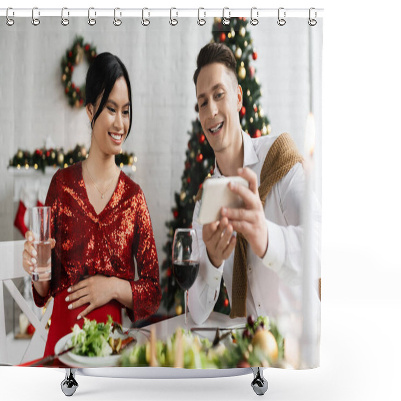 Personality  Pregnant Asian Woman With Glass Of Water Smiling Near Husband Showing Mobile Phone During Christmas Supper Shower Curtains