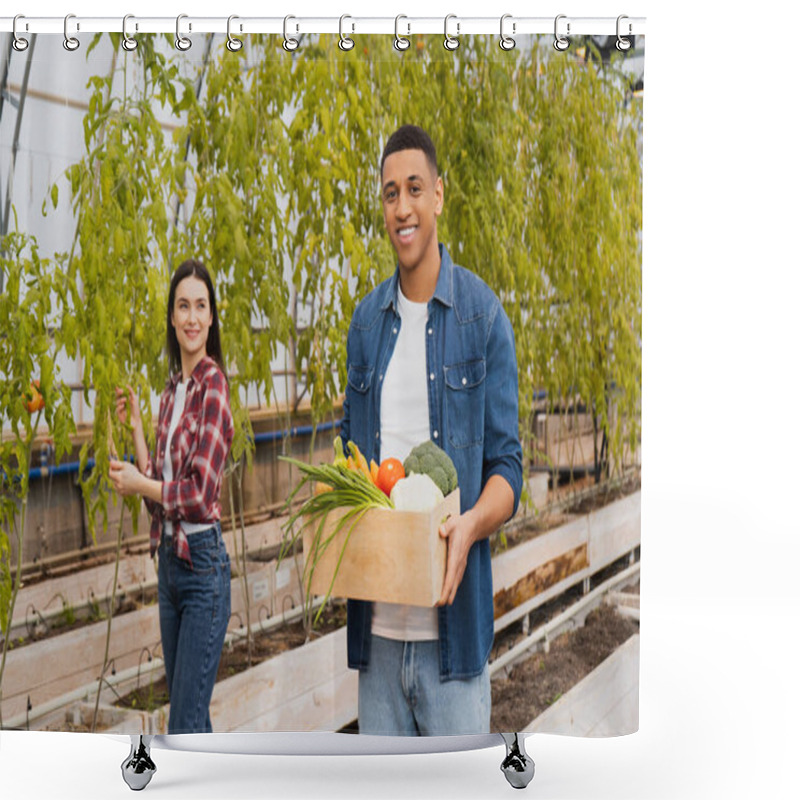 Personality  Positive African American Farmer Holding Box With Fresh Vegetables Near Colleague And Plants In Greenhouse  Shower Curtains