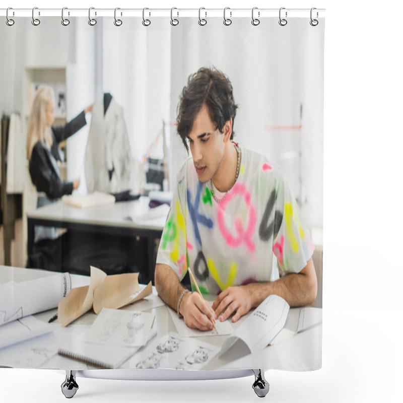 Personality  Creative Fashion Designer With Pencil Looking At Sketches While Working Near Blurred Colleague In Tailor Shop Shower Curtains