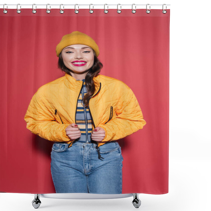 Personality  Happy Young Woman In Beanie Hat Adjusting Puffer Jacket And Smiling On Red Shower Curtains