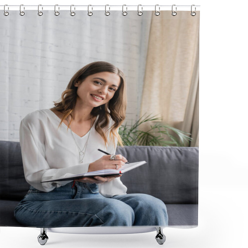 Personality  Charming And Happy Brunette Woman In White Blouse And Denim Jeans Looking At Camera While Sitting On Grey Couch And Writing In Notebook With Pen In Radio Studio Shower Curtains