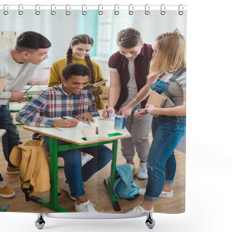 Personality  African American Schoolboy Writing In Notebook While His Classmates Standing Around Shower Curtains