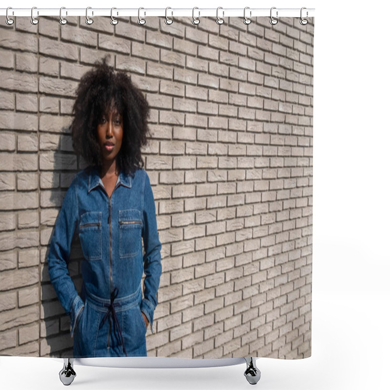 Personality  An African American Woman With Natural Afro-textured Hair Stands Confidently Against A White Brick Wall Backdrop. She Sports A Stylish Full Denim Jumpsuit That Cinches At The Waist, Complementing Her Shower Curtains