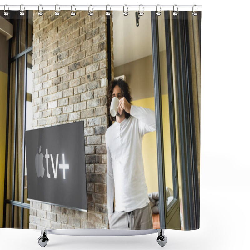 Personality  KYIV, UKRAINE - APRIL 25, 2020: Young Man In Pajamas Drinking Coffee While Standing Near Lcd Screen With Apple TV Shower Curtains