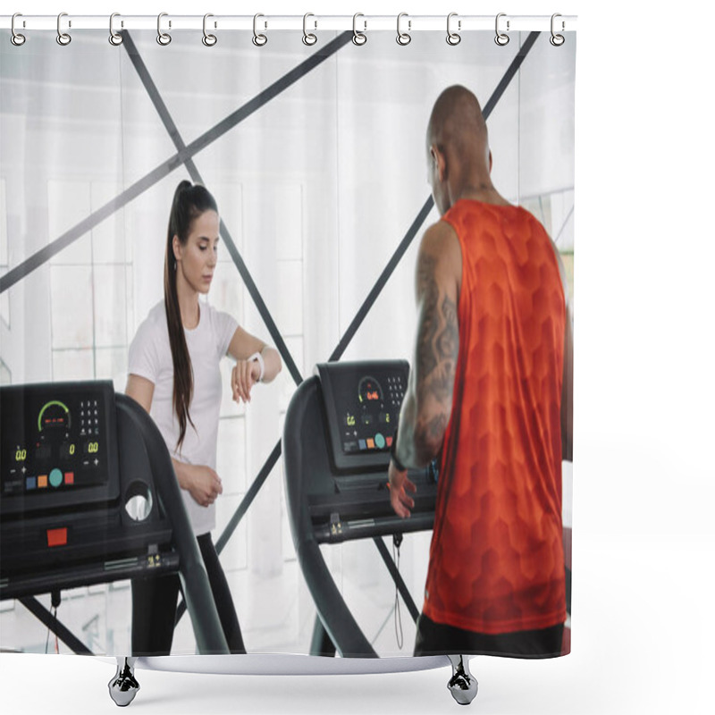 Personality  Attentive Trainer Looking At Fitness Tracker While Standing Near African American Sportsman Running On Treadmill Shower Curtains