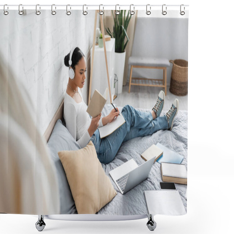 Personality  African American Student In Headphones Reading Book And Writing On Notebook Near Devices On Bed  Shower Curtains