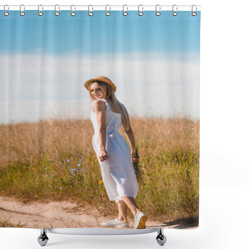 Personality  Young Blonde Woman In Straw Hat And White Dress Holding Wildflowers And Looking At Camera While Walking On Road In Field Shower Curtains