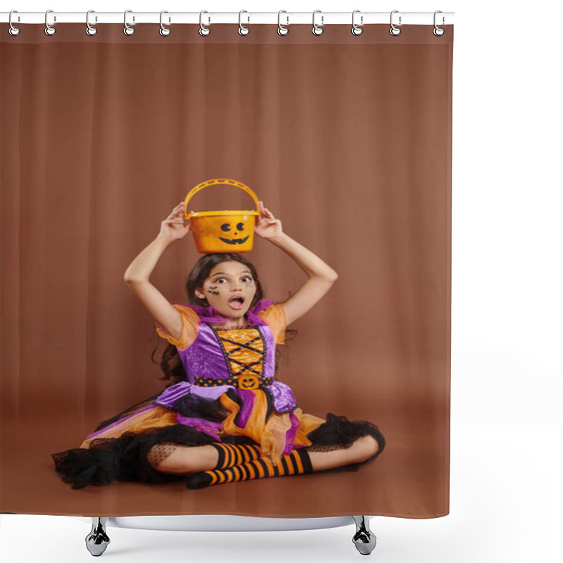 Personality  Astonished Girl In Halloween Costume Holding Candy Bucket On Head And Sitting On Brown Background Shower Curtains