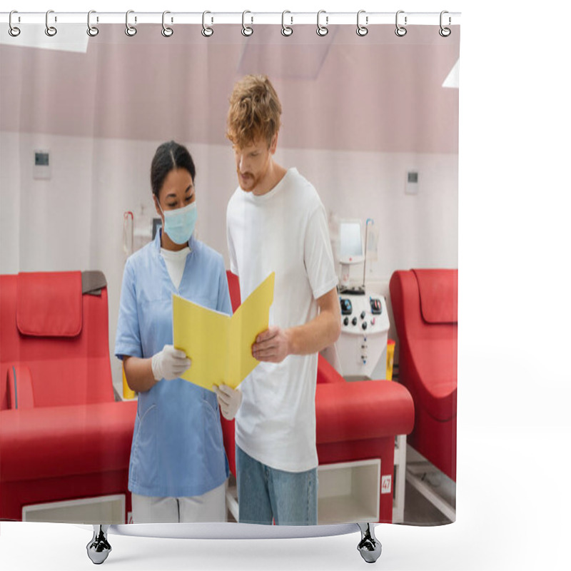 Personality  Redhead Volunteer And Multiracial Nurse In Uniform, Medical Mask And Latex Gloves Looking At Paper Folder Near Medical Chairs And Transfusion Machines In Blood Donation Center Shower Curtains