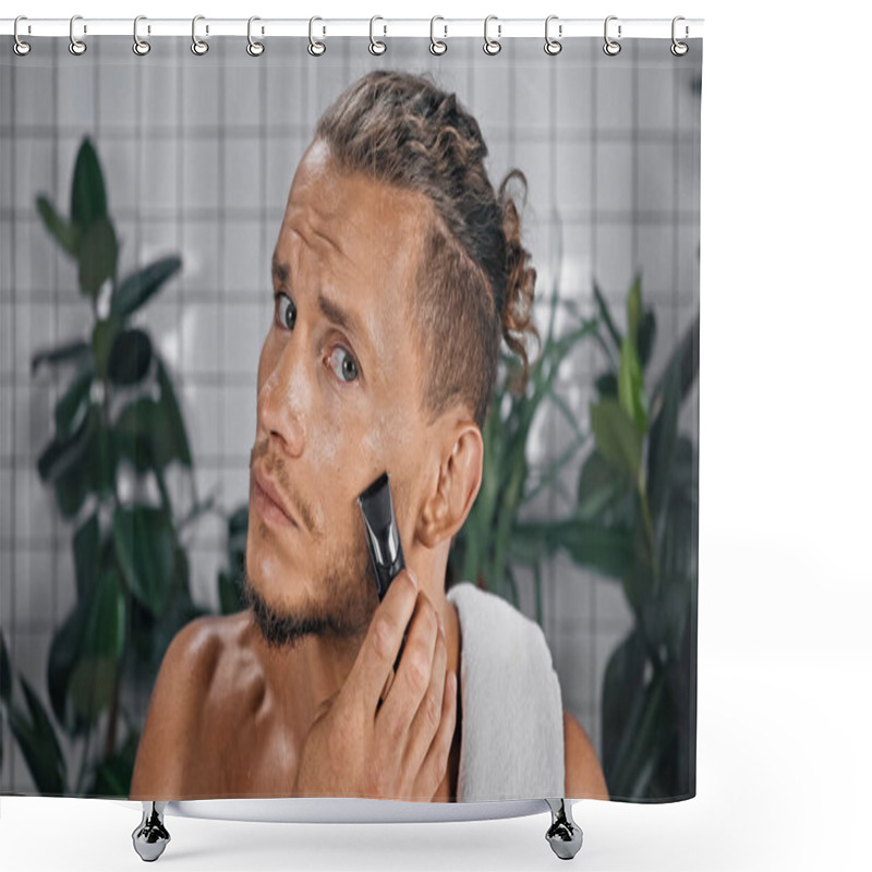 Personality  Shirtless Man Using Electric Razor And Looking At Camera In Bathroom Near Plants On Blurred Background Shower Curtains