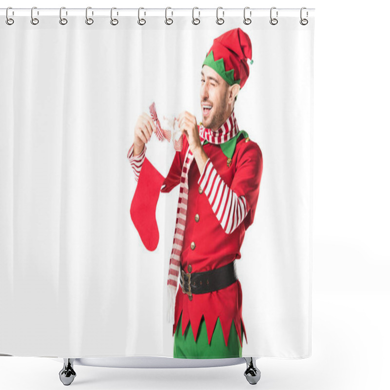 Personality  Man In Christmas Elf Costume Winging And Putting Present In Red Christmas Stocking Isolated On White Shower Curtains