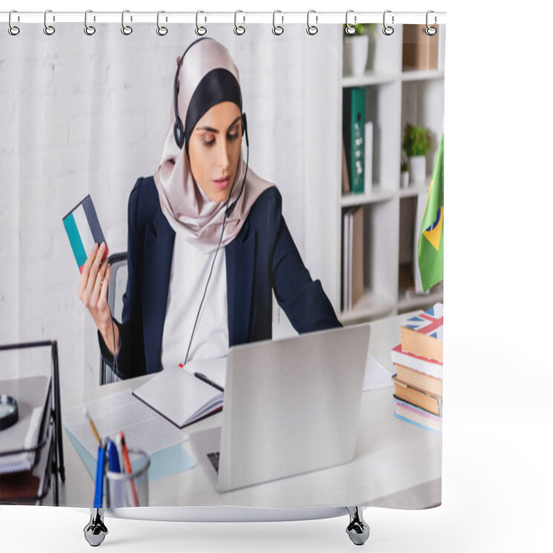 Personality  Arabian Interpreter In Headset Holding Digital Translator While Working On Laptop Near Dictionaries, Blurred Foreground Shower Curtains