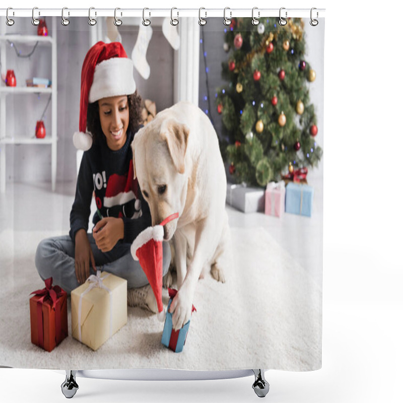 Personality  Labrador Dog With Santa Hat On Nose Touching Gift Box Near Happy African American Girl On Blurred Background Shower Curtains