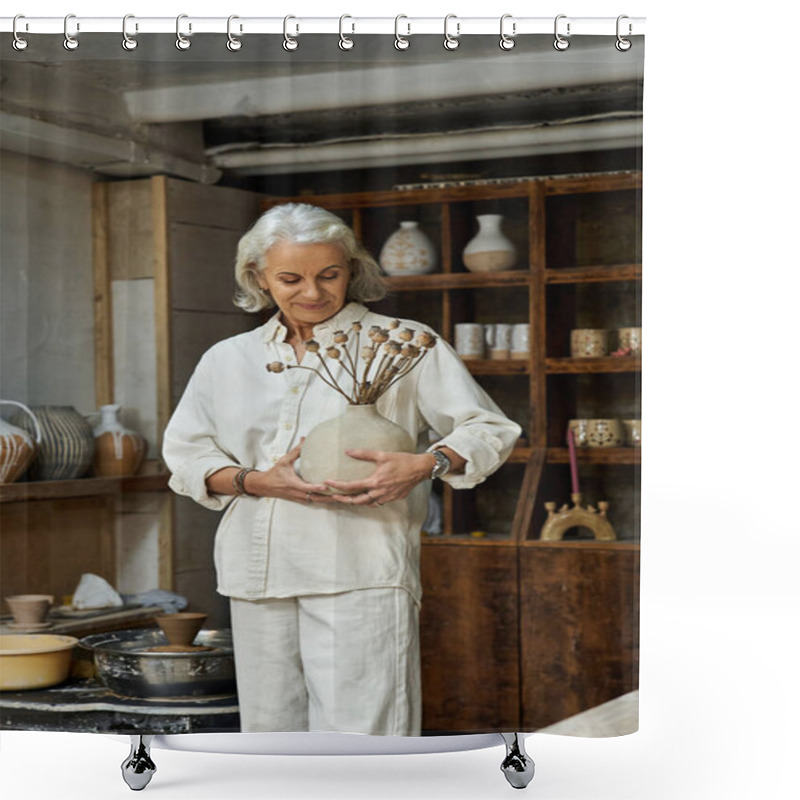 Personality  The Mature Woman Holds A Unique Vase Filled With Dried Flowers, Smiling Softly In Her Studio. Shower Curtains