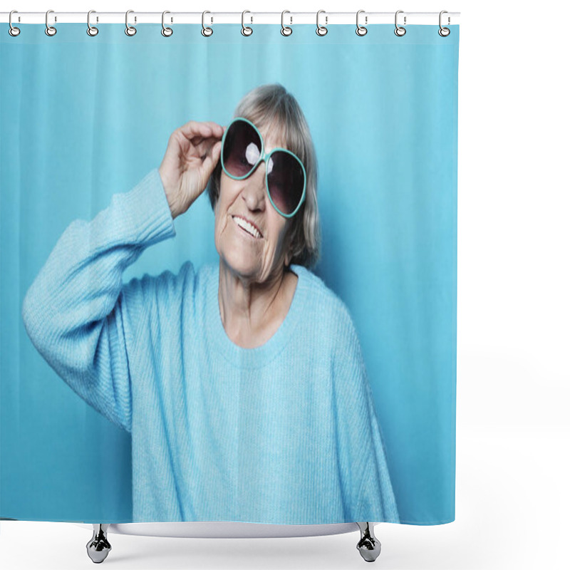 Personality  Lifestyle, Emotion And People Concept: Funny Old Lady Wearing Blue Sweater And Sunglasses. Isolated On Blue Background. Shower Curtains