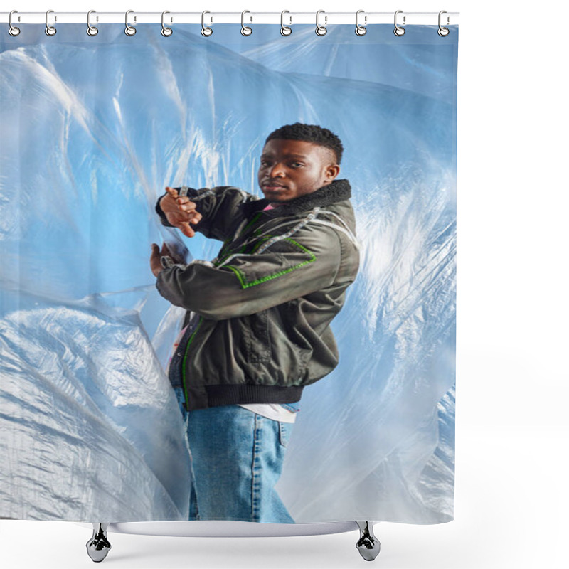 Personality  Confident Young Afroamerican Man In Ripped Jeans And Outwear Jacket With Led Stripes Touching Glossy Cellophane On Blue Background, Urban Outfit And Modern Pose, Creative Expression, DIY Clothing  Shower Curtains