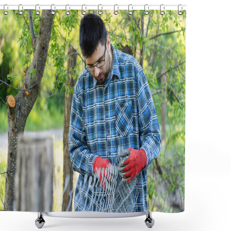 Personality  Close up on midsection of young adult caucasian man holding protective chain link diamond wire fence in the field in day with copy space shower curtains