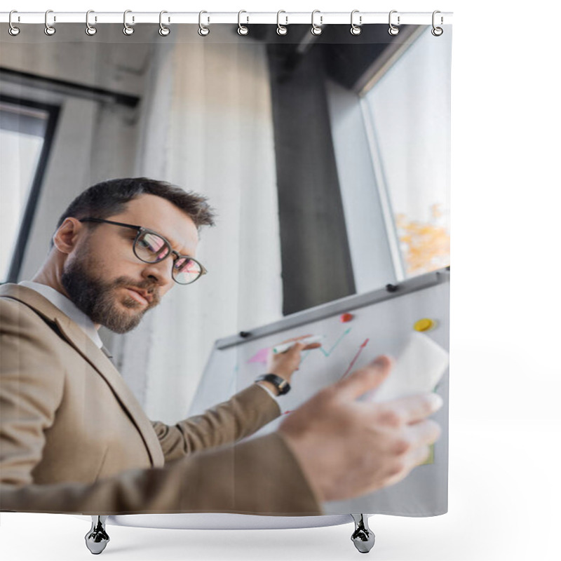 Personality  Low Angle View Of Thoughtful And Ambitious Businessman In Eyeglasses Looking At Mobile Phone And Holding Marker Near Flip Chart While Doing Market Research In Office Shower Curtains