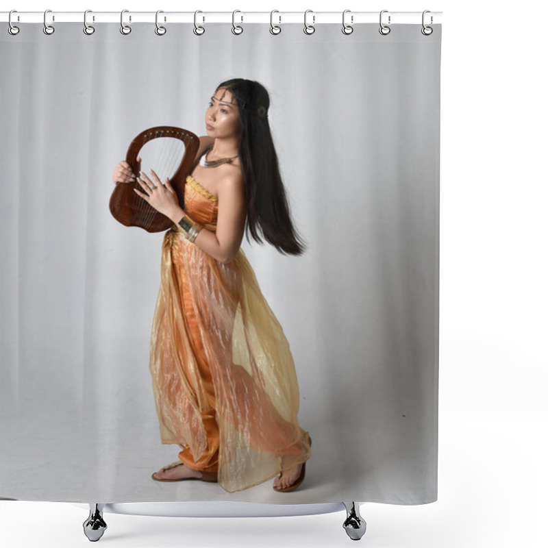 Personality  Full Length Portrait Of Pretty Young Asian Woman Wearing Golden Arabian Robes Like A Genie, Holding A Small Musical Harp, Isolated On Studio Background. Shower Curtains