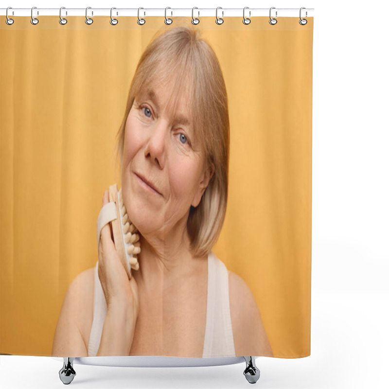 Personality  A Senior Woman Gently Massages Her Face With A Cleansing Brush, Smiling Softly As She Enjoys Her Self-care Moment Against A Vibrant Yellow Backdrop. Shower Curtains